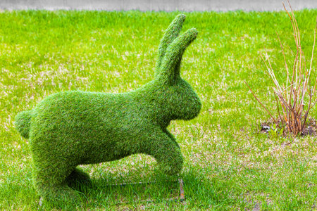landscape figure of a rabbit standing on the lawn. topiary figure of a rabbit. artificial topiary rabbit figure. green rabibt.の写真素材
