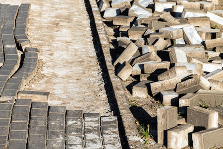 dismantling old paving stone tiles on the street, close-up. repair of pedestrian area with removal of stone tiles. re-laying of paving slabs. High quality photoの写真素材