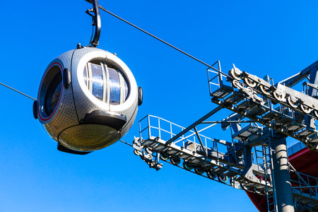 a cable car with round passenger cabins. cable car against blue sky. aerial tram station. the aerial tram arrives at the stationの写真素材