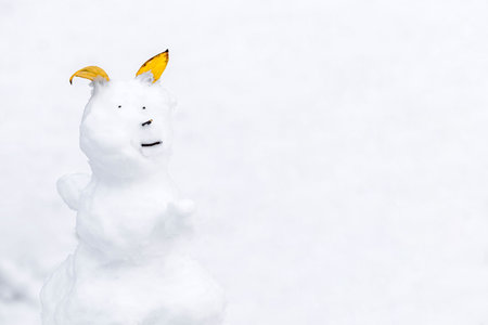 funny snowman on white background, close-up. snowman made of tree branches and leavesの写真素材