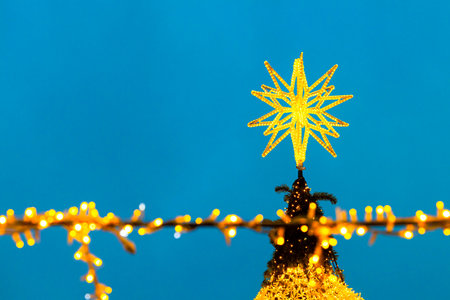 golden star on top of christmas tree. glowing star on top of christmas tree
