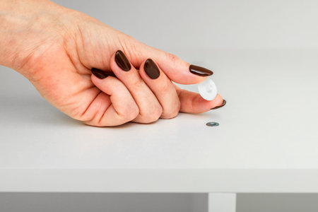 a hand installs a plastic plug for a Euro screw. Plastic plugs (covers) for Euro screws (confirmat)....