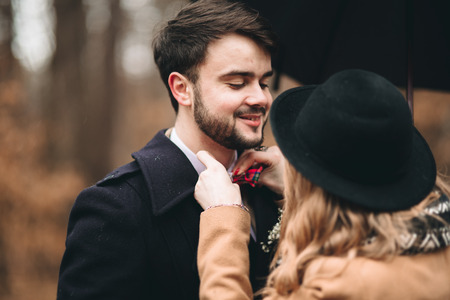 Romantic fairytale wedding couple, bride and groom, kissing and embracing in pine forest near retro car.の写真素材