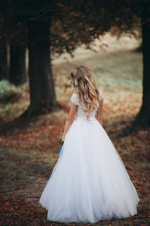Luxuty portrait of blonde bride with bridal bouquet in autumn.の写真素材