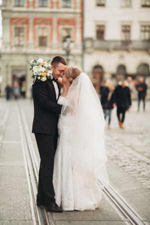 wedding couple is standing in the streets of old city.の写真素材