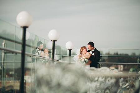 Stylish beautiful wedding couple hugging on background panoramic view of the old town.の写真素材