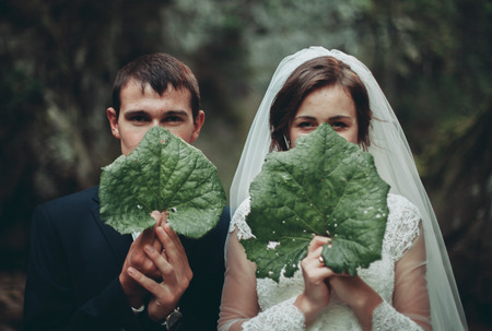 Beautiful wedding couple stay on stone of the river in scenic mountains.の写真素材