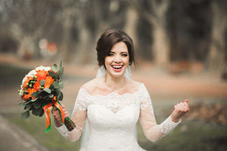 Beautiful bride in the park on her wedding day with bouquet.の写真素材