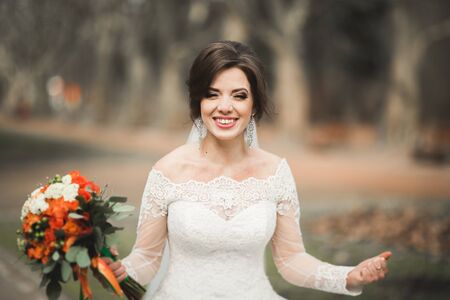 Beautiful bride in the park on her wedding day with bouquet.の写真素材