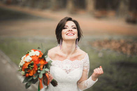 Beautiful bride in the park on her wedding day with bouquet.の写真素材