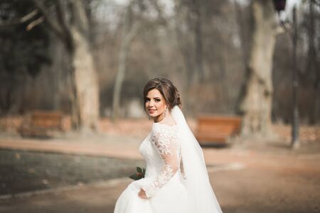 Beautiful bride in the park on her wedding day with bouquet.の写真素材