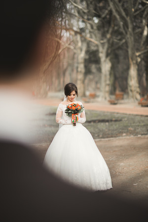 Beautiful couple of happy stylish newlyweds in the  park on their wedding day with bouquet.の写真素材