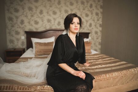 Luxury bride in black robe posing while preparing for the wedding ceremony.の写真素材