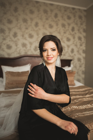 Luxury bride in black robe posing while preparing for the wedding ceremony.の写真素材