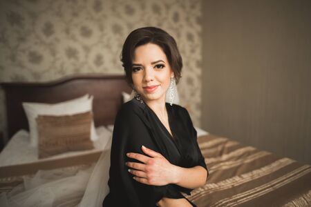 Luxury bride in black robe posing while preparing for the wedding ceremony.の写真素材