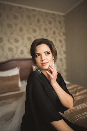 Luxury bride in black robe posing while preparing for the wedding ceremony.の写真素材
