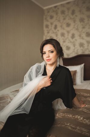 Luxury bride in black robe posing while preparing for the wedding ceremony.の写真素材