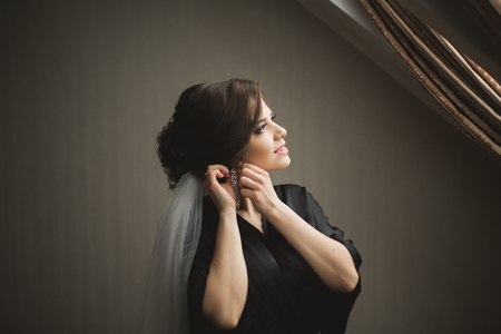 Luxury bride in black robe posing while preparing for the wedding ceremony.の写真素材