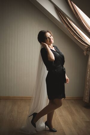 Luxury bride in black robe posing while preparing for the wedding ceremony.の写真素材