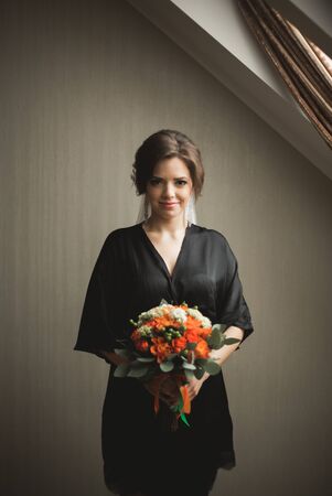 Luxury bride in black robe posing while preparing for the wedding ceremony.の写真素材