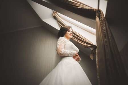 Luxury bride in white dress posing while preparing for the wedding ceremony.の写真素材