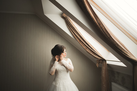 Luxury bride in white dress posing while preparing for the wedding ceremony.の写真素材