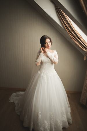 Luxury bride in white dress posing while preparing for the wedding ceremony.の写真素材