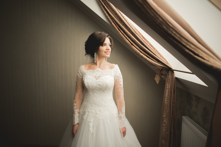 Luxury bride in white dress posing while preparing for the wedding ceremony.の写真素材