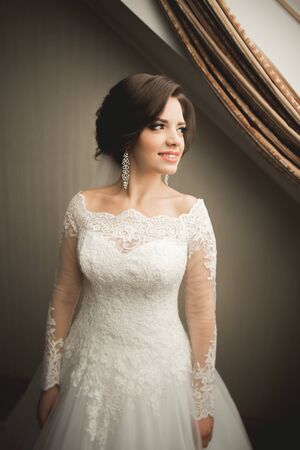 Luxury bride in white dress posing while preparing for the wedding ceremony.の写真素材