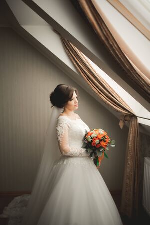 Luxury bride in white dress posing while preparing for the wedding ceremony.の写真素材