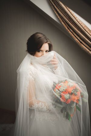 Luxury bride in white dress posing while preparing for the wedding ceremony.の写真素材