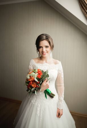 Luxury bride in white dress posing while preparing for the wedding ceremony.の写真素材