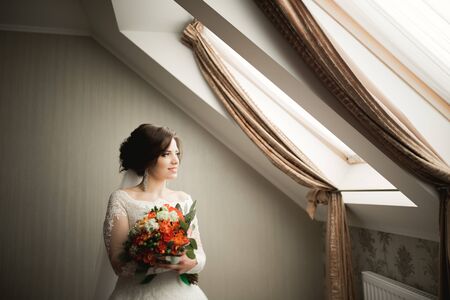 Luxury bride in white dress posing while preparing for the wedding ceremony.の写真素材