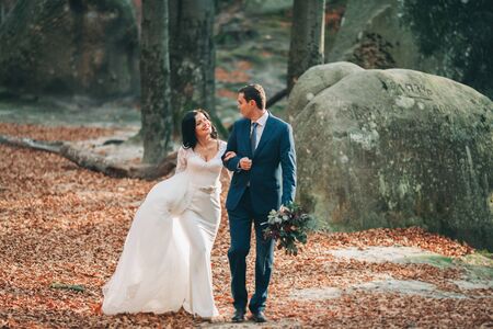 Gorgeous bride and groom kissing and hugging near the cliffs with stunning views.の写真素材