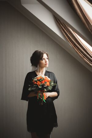 Luxury bride in black robe posing while preparing for the wedding ceremony.の写真素材