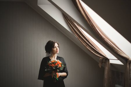 Luxury bride in black robe posing while preparing for the wedding ceremony.の写真素材