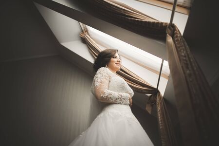 Luxury bride in white dress posing while preparing for the wedding ceremony.の写真素材