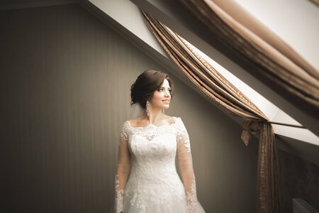 Luxury bride in white dress posing while preparing for the wedding ceremony.の写真素材