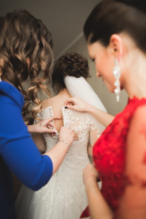 Happy buddies helps bride getting ready for her wedding day in the morning.の写真素材