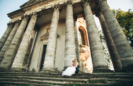 Beautiful romantic wedding couple of newlyweds hugging near old castle.の写真素材