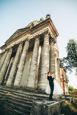 Beautiful romantic wedding couple of newlyweds hugging near old castle.の写真素材