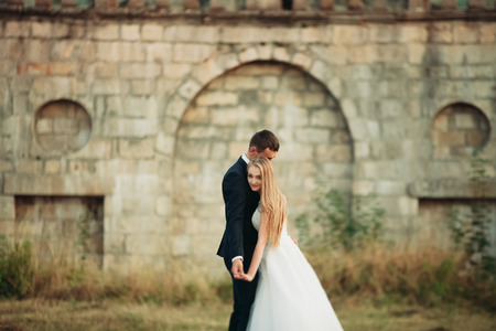 Beautiful romantic wedding couple of newlyweds hugging near old castle.の写真素材