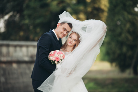 Beautiful romantic wedding couple of newlyweds hugging near old castle.の写真素材