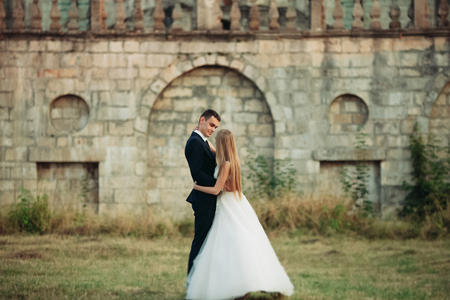Beautiful romantic wedding couple of newlyweds hugging near old castle.の写真素材