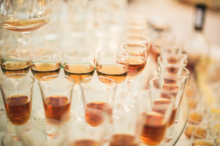 Different alcohol drinks in goblets and wine glasses on wedding buffet table.の写真素材