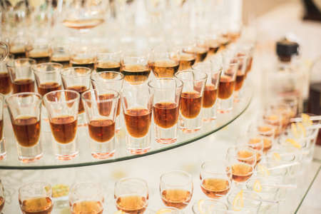 Different alcohol drinks in goblets and wine glasses on wedding buffet table.の写真素材