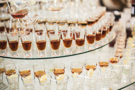 Different alcohol drinks in goblets and wine glasses on wedding buffet table.の写真素材