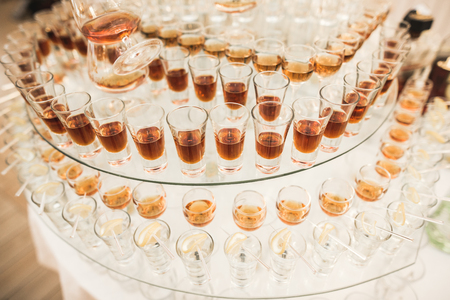 Different alcohol drinks in goblets and wine glasses on wedding buffet table.の写真素材