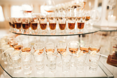 Different alcohol drinks in goblets and wine glasses on wedding buffet table.の写真素材