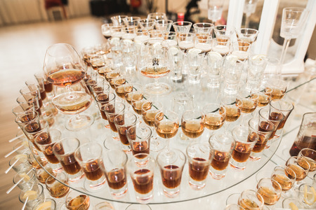 Different alcohol drinks in goblets and wine glasses on wedding buffet table.の写真素材